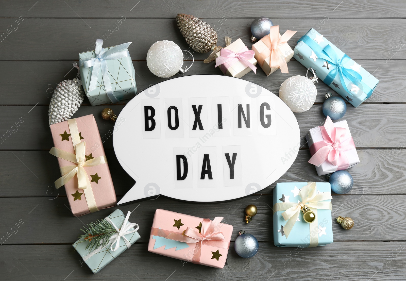 Flat lay composition with Boxing Day sign and Christmas gifts on grey wooden table Photo of Flat lay composition with Boxing Day sign and Christmas gifts on grey wooden table
