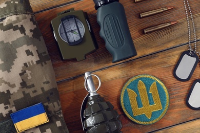 MYKOLAIV, UKRAINE - SEPTEMBER 26, 2020: Tactical gear, military uniform and Ukrainian army patches on wooden table, flat lay Photo of MYKOLAIV, UKRAINE - SEPTEMBER 26, 2020: Tactical gear, military uniform and Ukrainian army patches on wooden table, flat lay