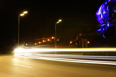 Road with light trails in modern city. Night life Photo of Road with light trails in modern city. Night life
