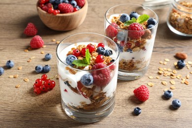 Tasty dessert with yogurt, berries and granola on wooden table Image of Tasty dessert with yogurt, berries and granola on wooden table