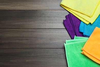 Many colorful microfiber cloths on wooden table, flat lay. Space for text Photo of Many colorful microfiber cloths on wooden table, flat lay. Space for text