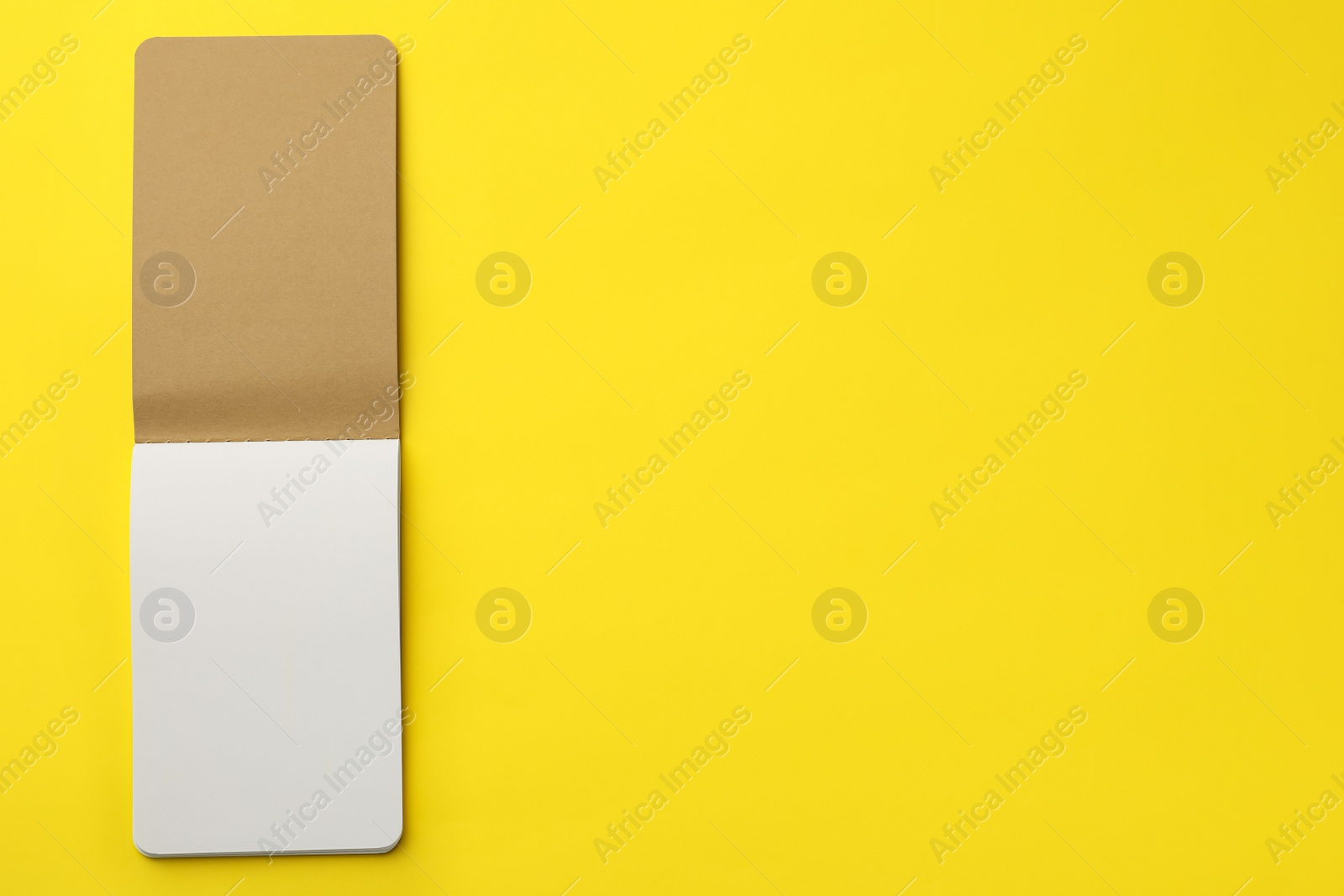 Stylish open notebook with blank sheets on yellow background, top view. Space for text Photo of Stylish open notebook with blank sheets on yellow background, top view. Space for text