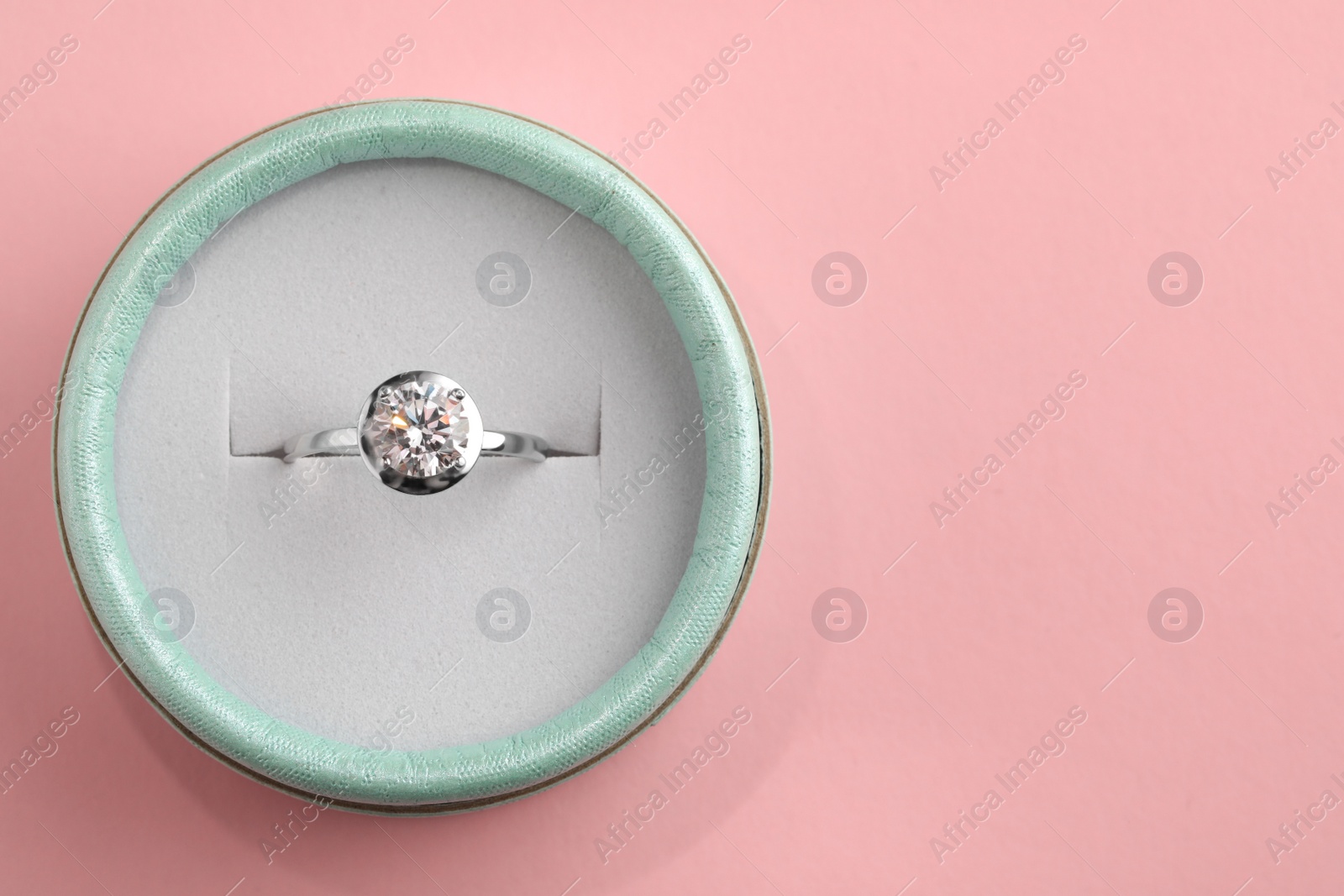 Beautiful box with engagement ring on pink background, top view. Space for text Photo of Beautiful box with engagement ring on pink background, top view. Space for text