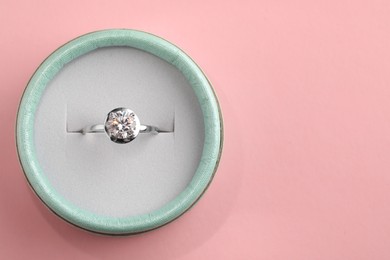 Beautiful box with engagement ring on pink background, top view. Space for text Photo of Beautiful box with engagement ring on pink background, top view. Space for text