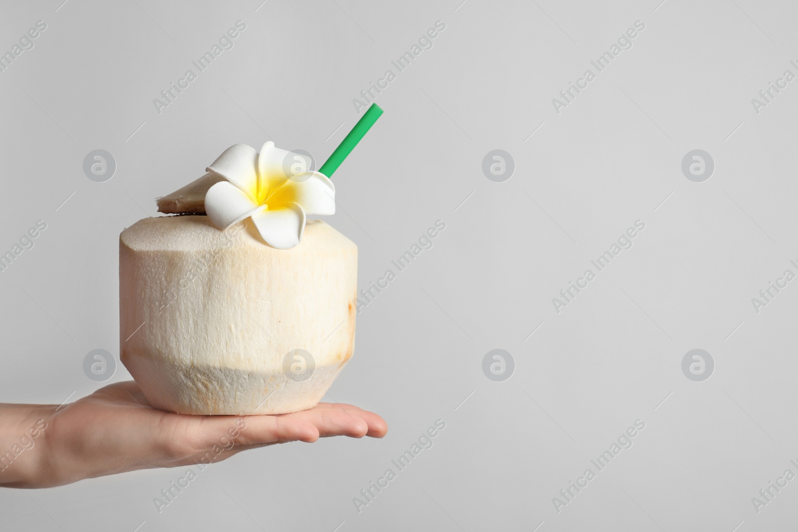 Woman with fresh coconut drink in nut on light background, closeup Photo of Woman with fresh coconut drink in nut on light background, closeup