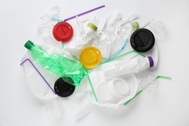 Pile of different plastic items on white background, flat lay Photo of Pile of different plastic items on white background, flat lay