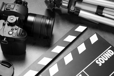 Clapboard with camera and tripod on grey background. Video production industry Photo of Clapboard with camera and tripod on grey background. Video production industry