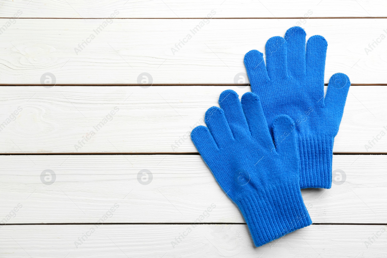 Stylish blue gloves on white wooden background, flat lay. Space for text Photo of Stylish blue gloves on white wooden background, flat lay. Space for text