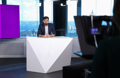 Presenter and video camera operator working in studio. News broadcasting Photo of Presenter and video camera operator working in studio. News broadcasting