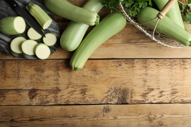 Green ripe zucchinis on wooden table, flat lay. Space for text Photo of Green ripe zucchinis on wooden table, flat lay. Space for text