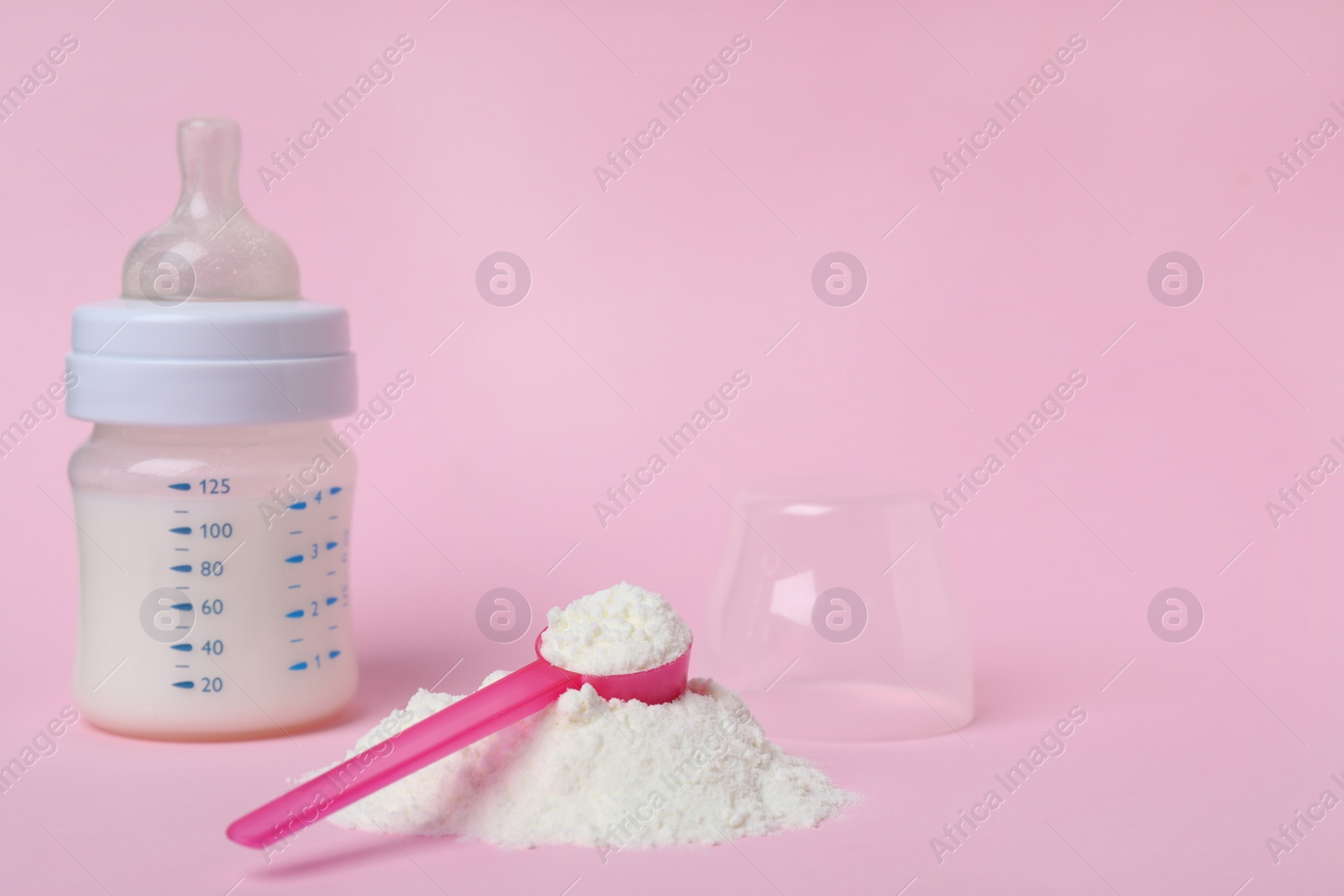 Powdered infant formula with scoop and feeding bottle on pink background, space for text. Baby milk Photo of Powdered infant formula with scoop and feeding bottle on pink background, space for text. Baby milk