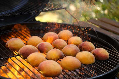Modern grill with tasty juicy peaches and flame outdoors, closeup Photo of Modern grill with tasty juicy peaches and flame outdoors, closeup