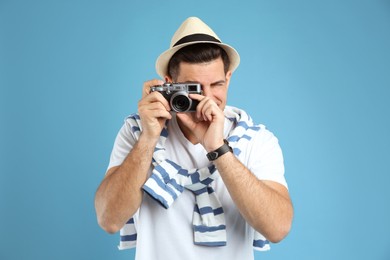 Male tourist taking picture on turquoise background Photo of Male tourist taking picture on turquoise background