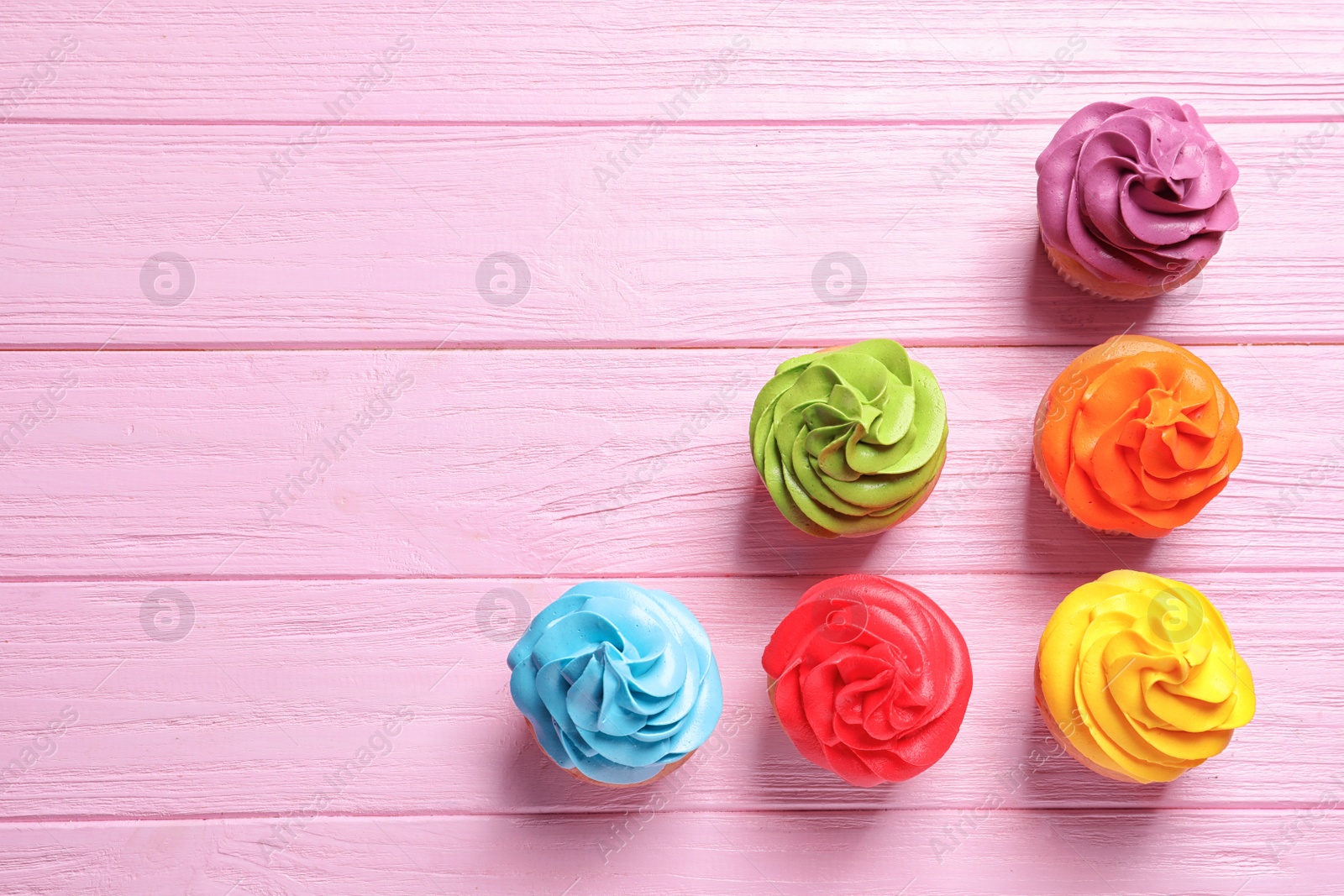 Delicious birthday cupcakes on wooden background Photo of Delicious birthday cupcakes on wooden background