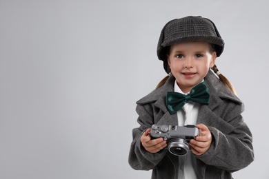 Cute little detective with vintage camera on grey background. Space for text Photo of Cute little detective with vintage camera on grey background. Space for text