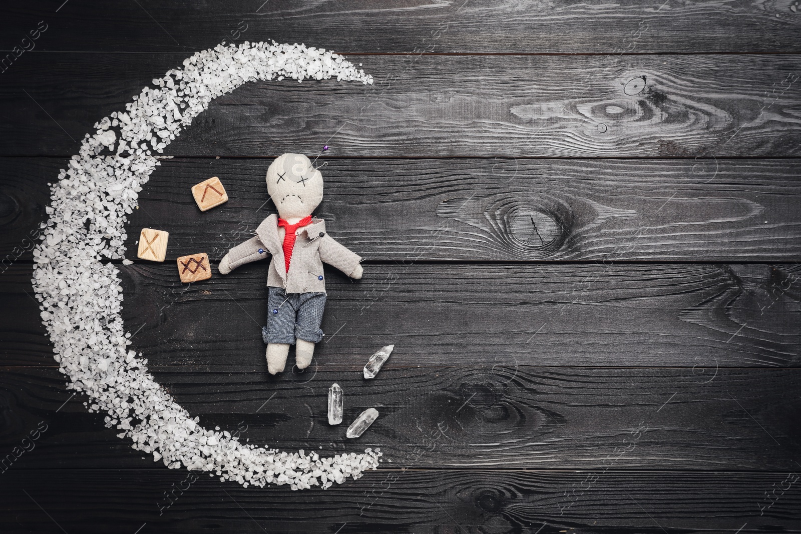 Voodoo doll pierced with pins and ceremonial items on black wooden table, flat lay. Space for text Photo of Voodoo doll pierced with pins and ceremonial items on black wooden table, flat lay. Space for text