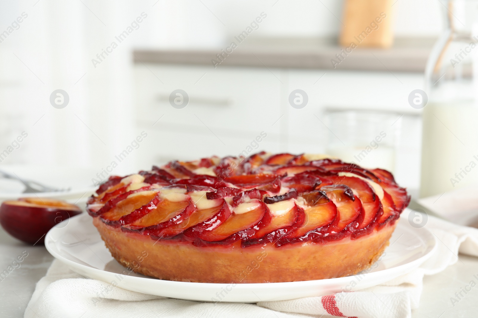Delicious cake with plums on light table, closeup Photo of Delicious cake with plums on light table, closeup