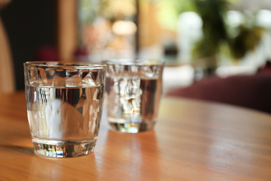 Glasses of water on wooden table in cafe. Space for text Photo of Glasses of water on wooden table in cafe. Space for text