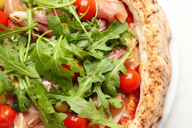 Tasty pizza with meat and arugula on white table, top view Photo of Tasty pizza with meat and arugula on white table, top view