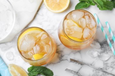 Delicious iced tea on white marble table, flat lay Photo of Delicious iced tea on white marble table, flat lay