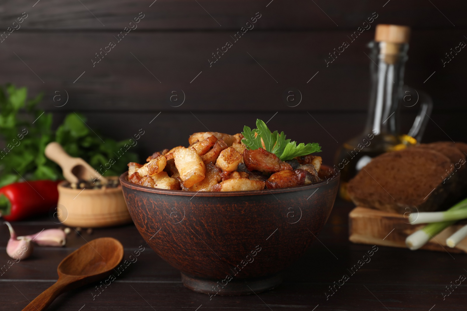 Tasty fried cracklings on wooden table. Cooked pork lard Photo of Tasty fried cracklings on wooden table. Cooked pork lard