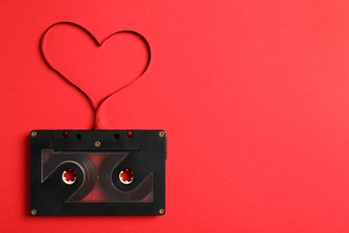 Top view of music cassette and heart made with tape on red background, space for text. Listening love song Photo of Top view of music cassette and heart made with tape on red background, space for text. Listening love song