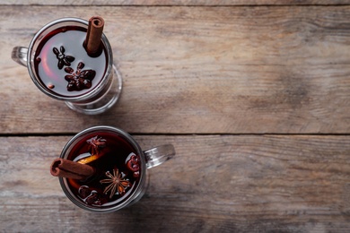 Delicious red mulled wine on wooden table, flat lay. Space for text Photo of Delicious red mulled wine on wooden table, flat lay. Space for text