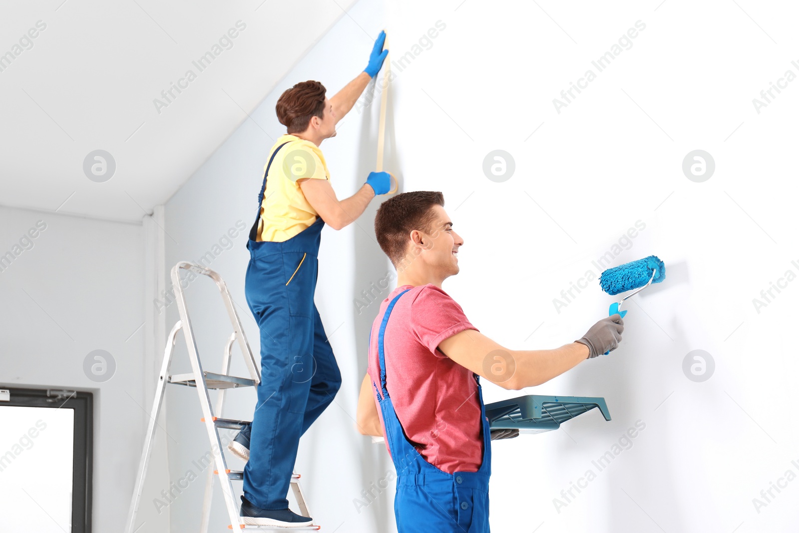 Male decorators refurbishing empty room Photo of Male decorators refurbishing empty room