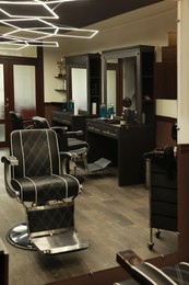 Stylish hairdresser's workplace with professional armchair in barbershop Photo of Stylish hairdresser's workplace with professional armchair in barbershop