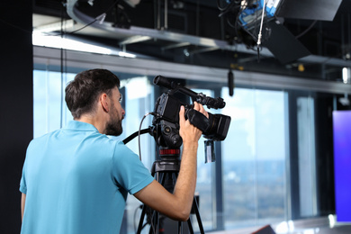 Photo of Professional video camera operator working in studio