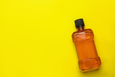 Mouthwash on yellow background, top view. Space for text Photo of Mouthwash on yellow background, top view. Space for text