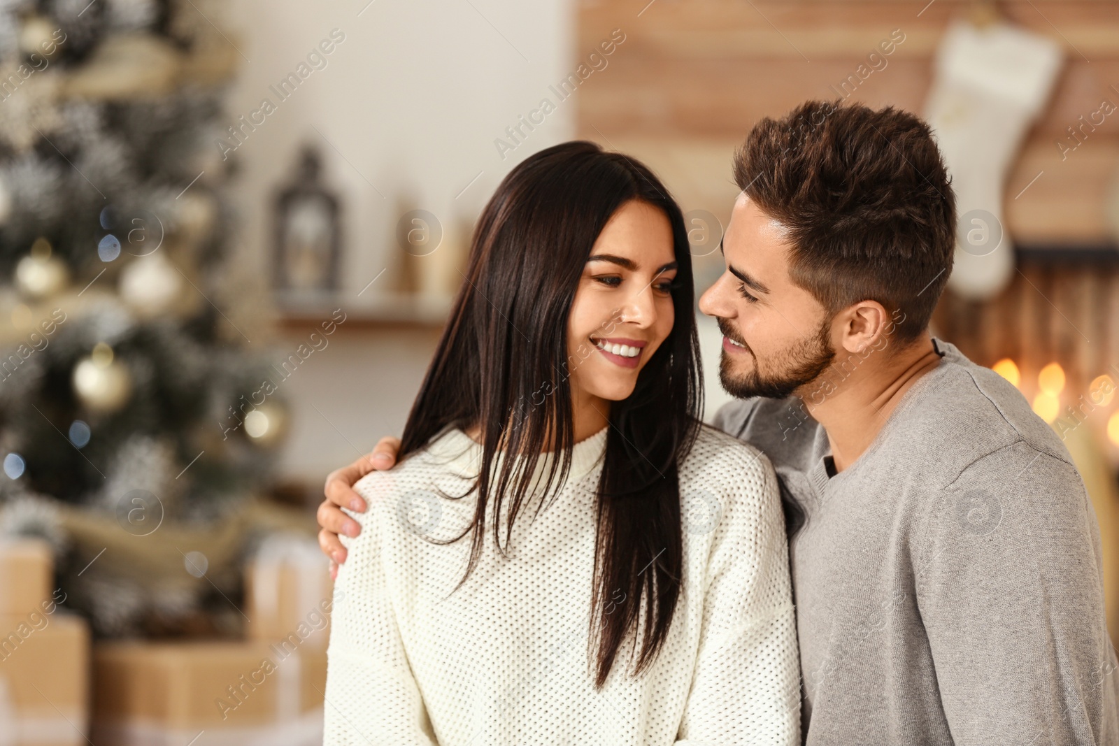 Happy couple in living room decorated for Christmas Image of Happy couple in living room decorated for Christmas