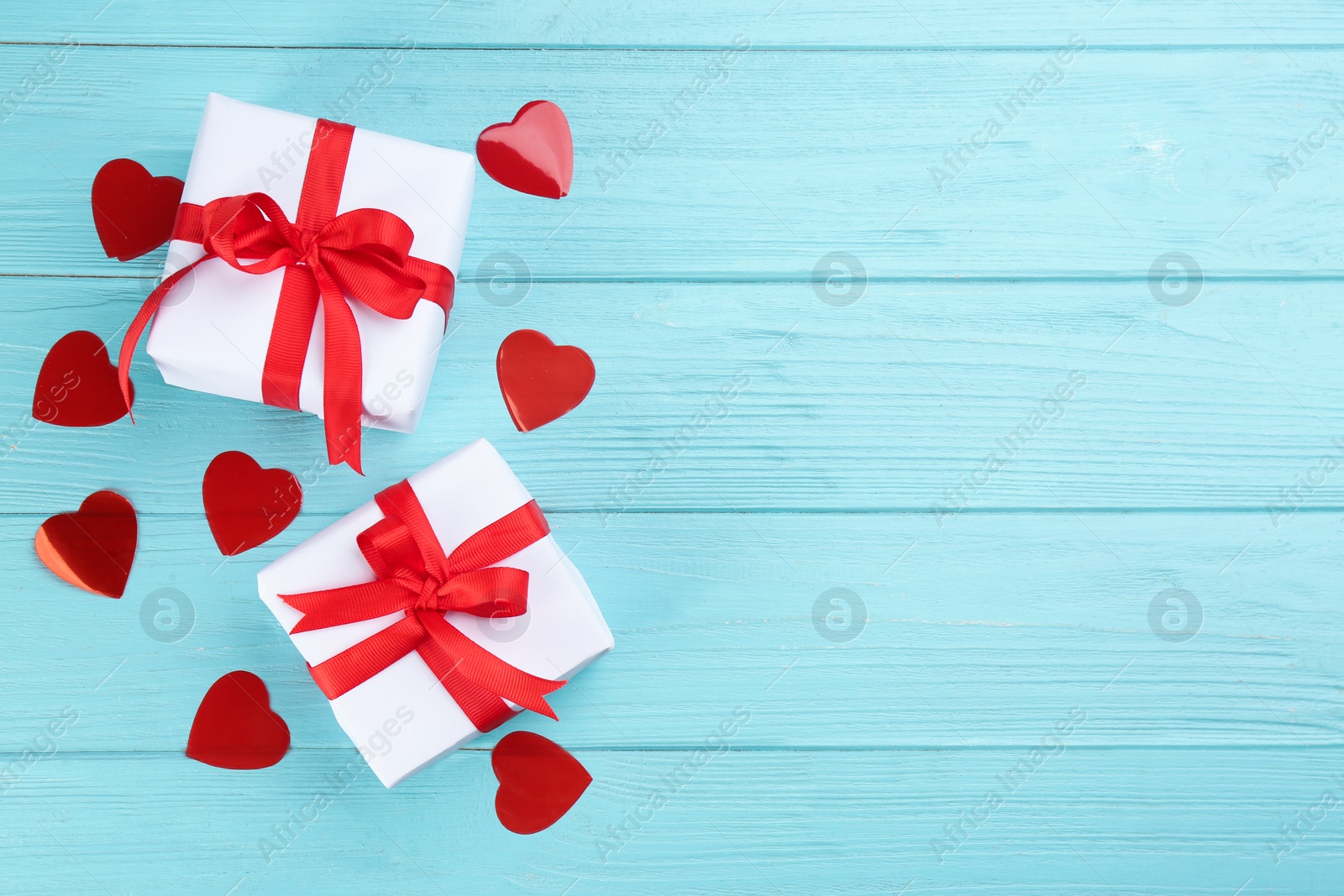 Photo of Gift boxes and hearts on turquoise wooden background, flat lay with space for text. Valentine's Day celebration