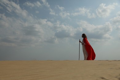 Jesus Christ walking with stick in desert. Space for text Photo of Jesus Christ walking with stick in desert. Space for text