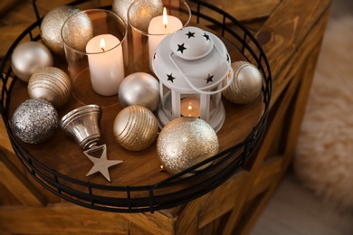 Burning candles, lantern and Christmas balls on wooden box indoors, above view Photo of Burning candles, lantern and Christmas balls on wooden box indoors, above view