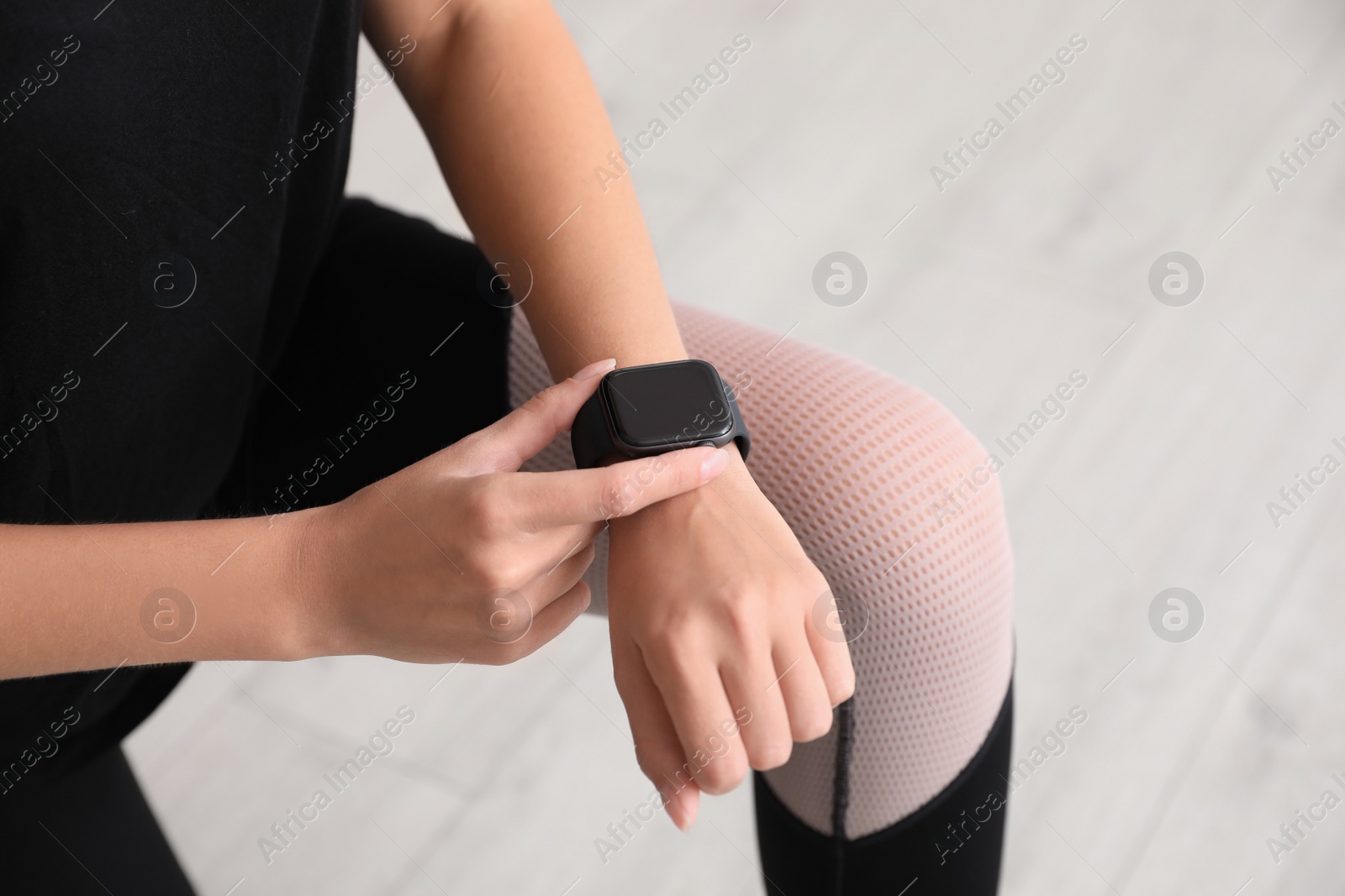 Woman using stylish smart watch indoors, closeup Image of Woman using stylish smart watch indoors, closeup