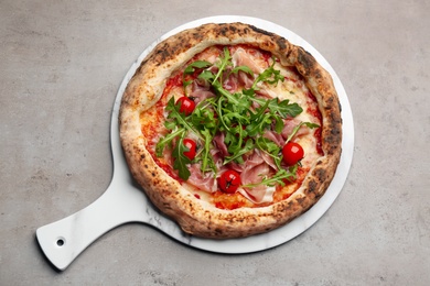 Tasty pizza with meat and arugula on grey table, top view Photo of Tasty pizza with meat and arugula on grey table, top view