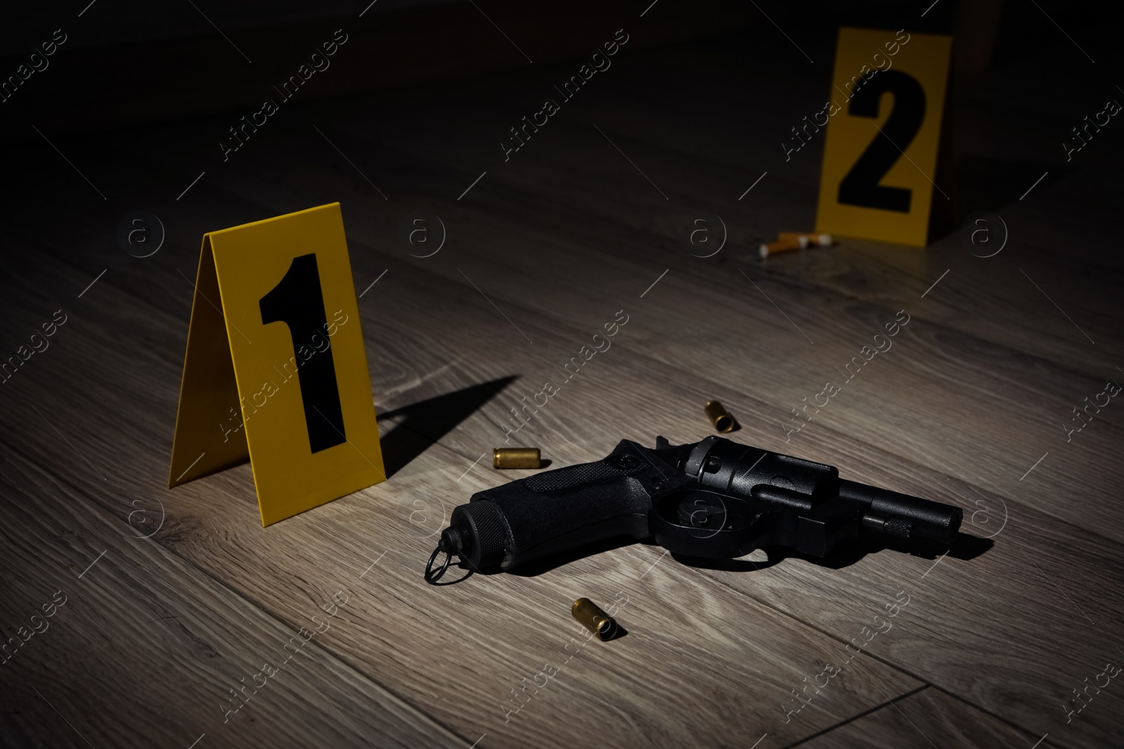 Photo of Gun and shell casings on wooden floor at crime scene