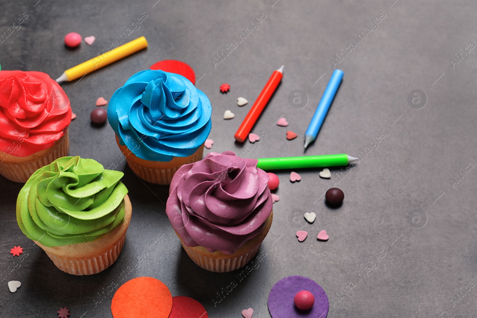 Delicious birthday cupcakes on gray background Photo of Delicious birthday cupcakes on gray background