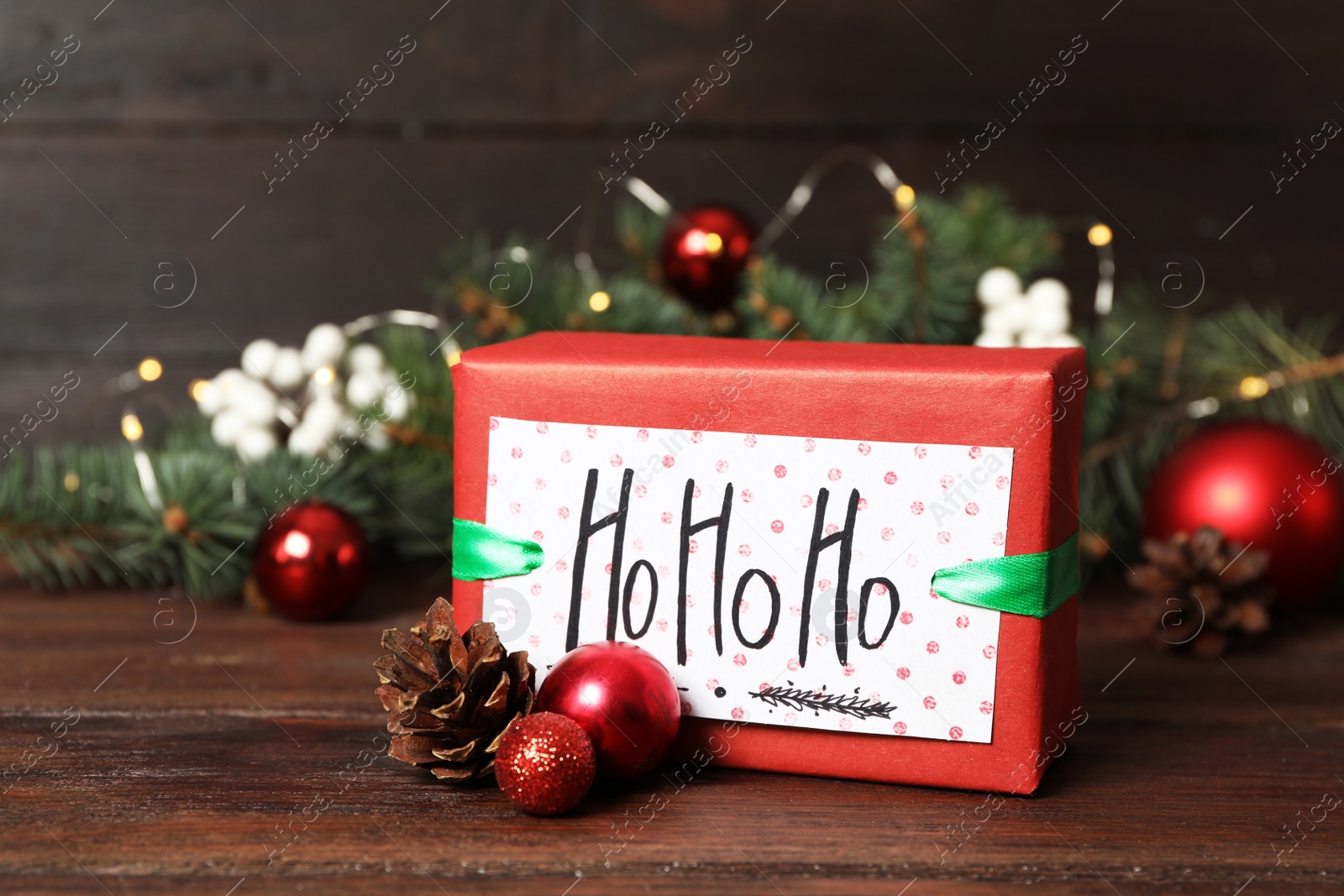 Gift box with Christmas balls and fir tree branches on wooden table Photo of Gift box with Christmas balls and fir tree branches on wooden table