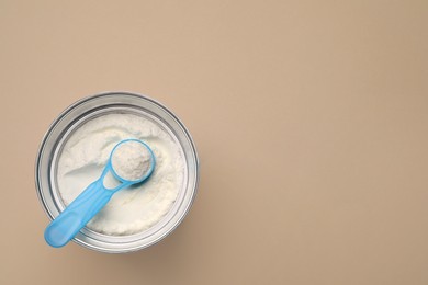 Top view of powdered infant formula with scoop in can on beige background, space for text. Baby milk Photo of Top view of powdered infant formula with scoop in can on beige background, space for text. Baby milk