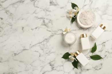 Beautiful jasmine flowers, skin care products and sea salt on white marble table, flat lay. Space for text Photo of Beautiful jasmine flowers, skin care products and sea salt on white marble table, flat lay. Space for text