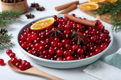 Fresh ripe cranberries and spices on white wooden table Photo of Fresh ripe cranberries and spices on white wooden table