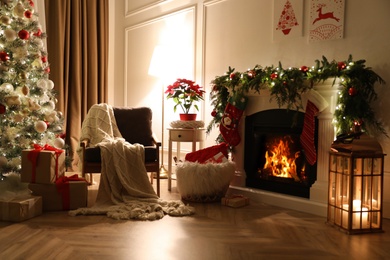 Photo of Stylish room interior with fireplace and beautiful Christmas tree