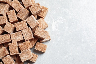 Cubes of brown sugar on gray background Photo of Cubes of brown sugar on gray background