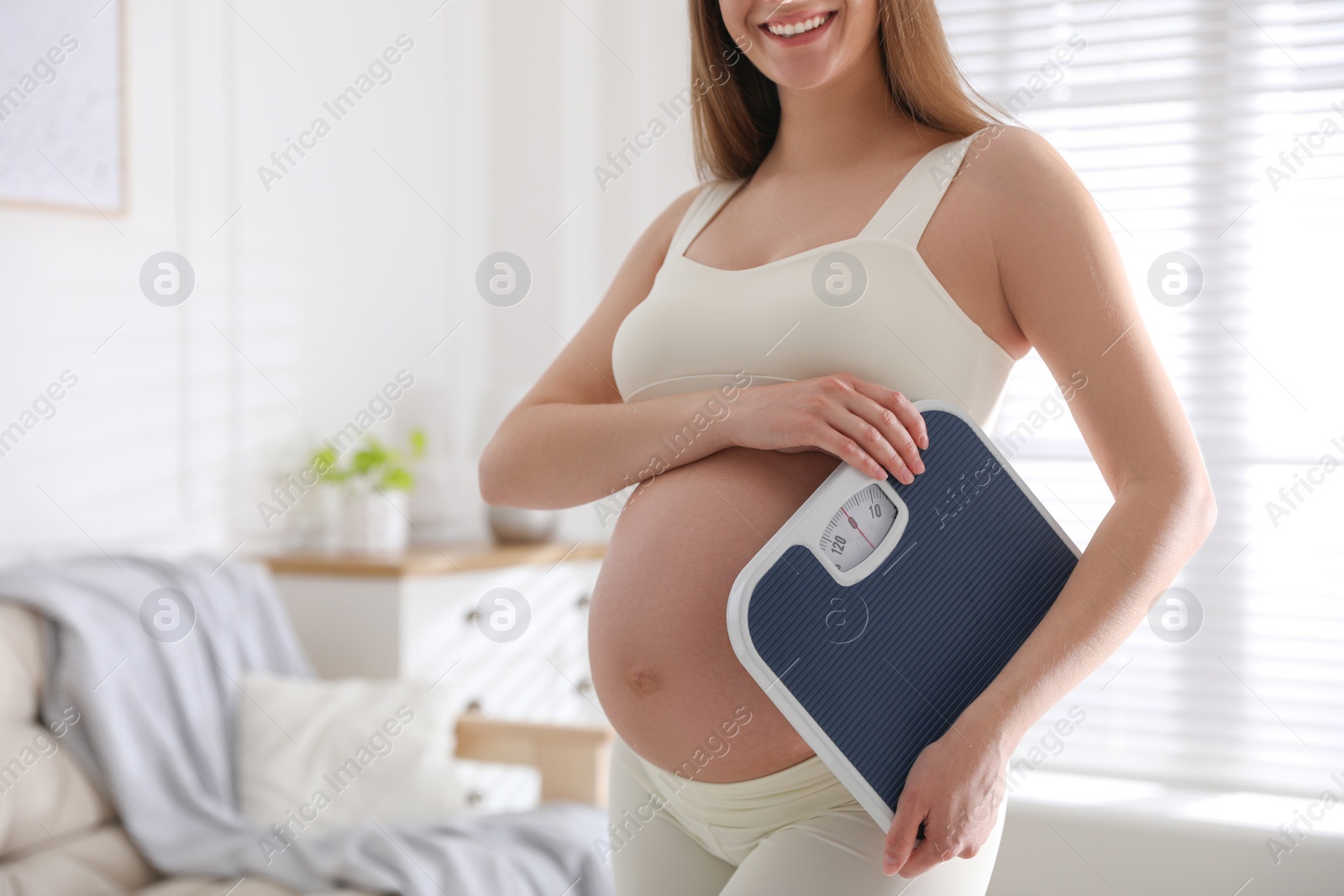 Young pregnant woman with scales at home, closeup Photo of Young pregnant woman with scales at home, closeup