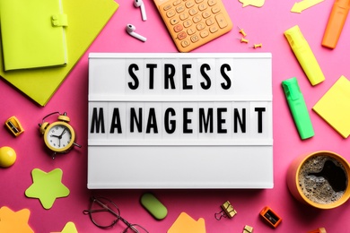 Flat lay composition of lightbox with phrase Stress Management on pink background Photo of Flat lay composition of lightbox with phrase Stress Management on pink background