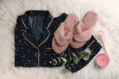 Flat lay composition with house slippers and pajamas on light faux fur Photo of Flat lay composition with house slippers and pajamas on light faux fur
