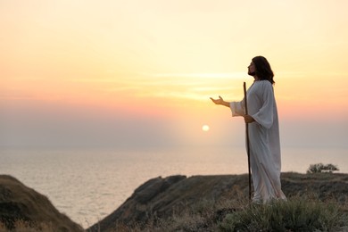 Jesus Christ on hills at sunset. Space for text Photo of Jesus Christ on hills at sunset. Space for text