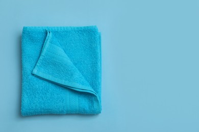 Folded soft beach towel on light blue background, top view. Space for text Photo of Folded soft beach towel on light blue background, top view. Space for text